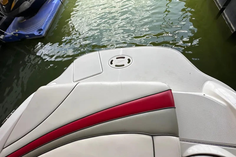 Slide: The Image of 2005 Sea Ray 200 Select boat with red and white seating, docked on calm water. - 20