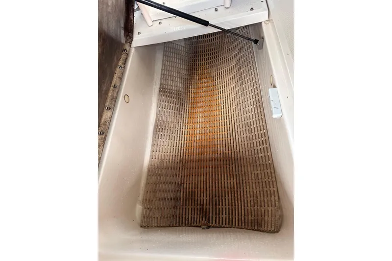 Slide: The Image of Storage compartment of a 2005 Sea Ray 200 Select boat with a woven mat. - 24
