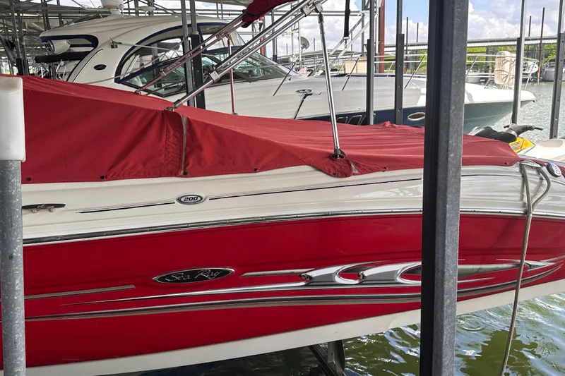 Slide: The Image of Red 2005 Sea Ray 200 Select boat docked with cover, surrounded by other boats. - 3