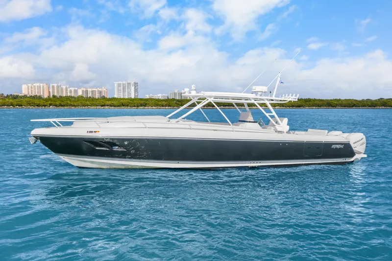 Slide: The Image of 2013 Intrepid 400 Cuddy boat cruising on blue water with city skyline in background. - 12