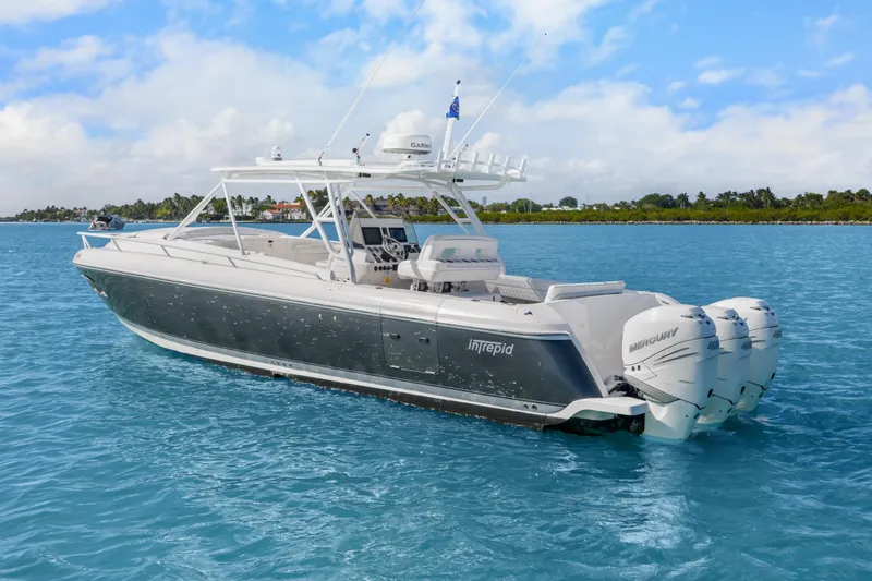 Slide: The Image of 2013 Intrepid 400 Cuddy boat cruising on clear blue water. - 13