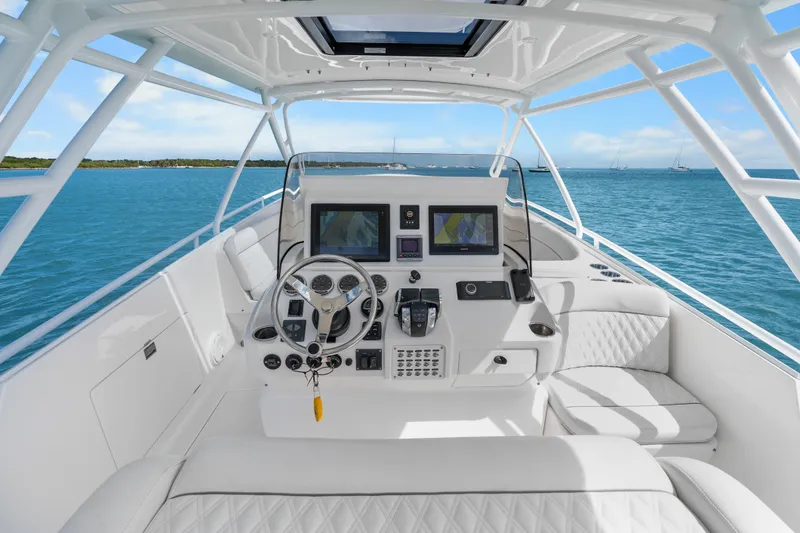 Slide: The Image of 2013 Intrepid 400 Cuddy helm with dual screens, steering wheel, and ocean view. - 18