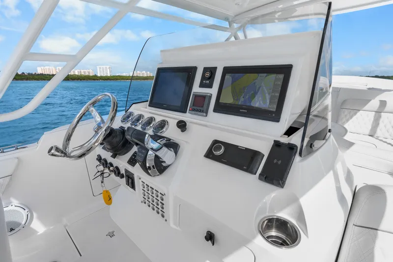 Slide: The Image of Helm of 2013 Intrepid 400 Cuddy with navigation screens and controls, overlooking blue waters. - 19