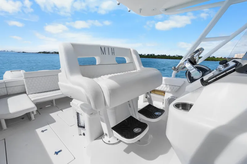 Slide: The Image of 2013 Intrepid 400 Cuddy boat interior with white seating and ocean view. - 20