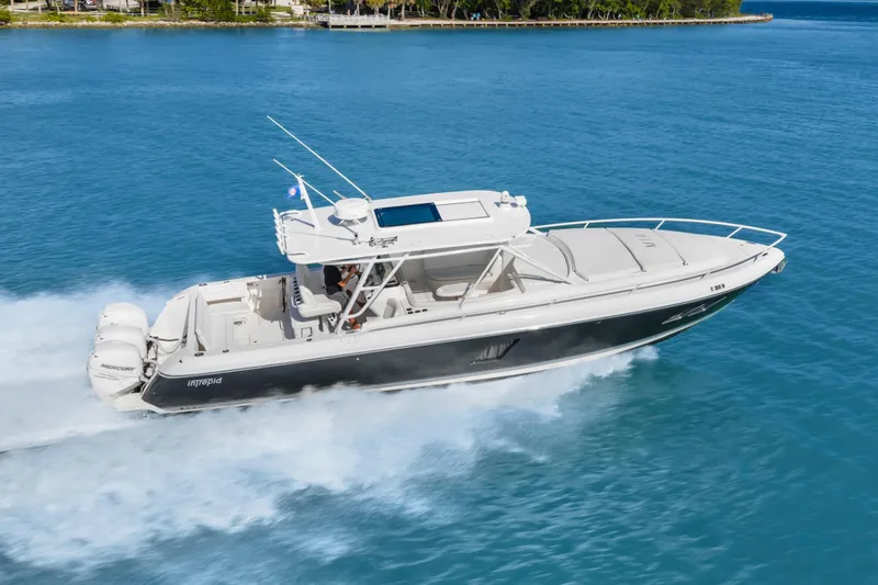 Slide: The Image of 2013 Intrepid 400 Cuddy cruising on clear blue water, showcasing sleek design and powerful engines. - 3