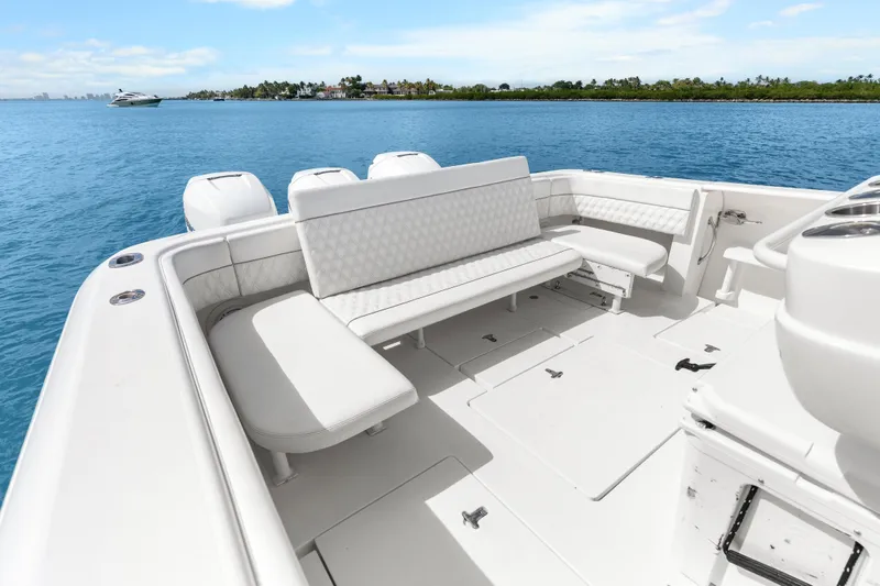 Slide: The Image of 2013 Intrepid 400 Cuddy boat interior with white seating on calm blue water. - 31