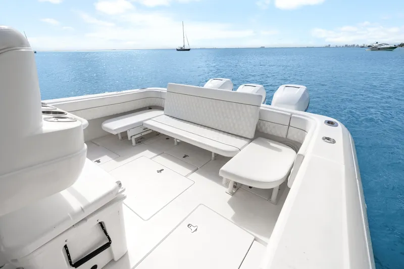 Slide: The Image of 2013 Intrepid 400 Cuddy boat interior with seating, ocean view, and clear sky. - 32