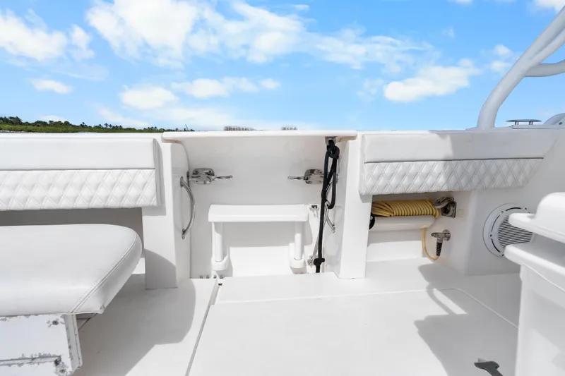 Slide: The Image of 2013 Intrepid 400 Cuddy boat interior with white seating and storage compartments. - 33