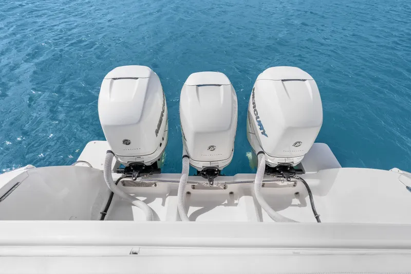 Slide: The Image of Triple Mercury outboard engines on a 2013 Intrepid 400 Cuddy boat in clear blue water. - 34