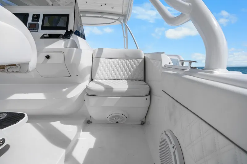 Slide: The Image of 2013 Intrepid 400 Cuddy interior with white seating and control panel, under blue sky. - 36