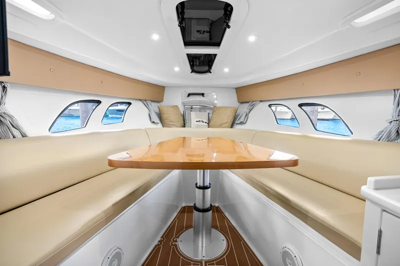 Slide: The Image of Interior of 2013 Intrepid 400 Cuddy boat with beige seating and wooden table. - 42