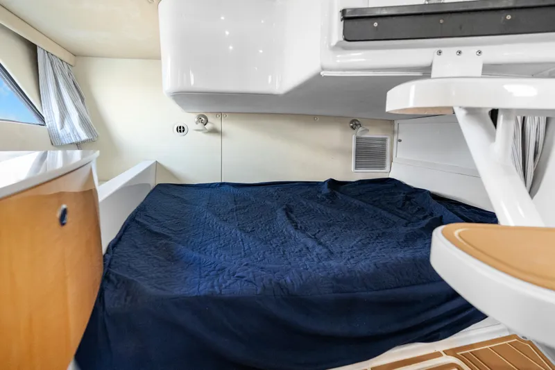 Slide: The Image of Cozy cabin interior of 2013 Intrepid 400 Cuddy with blue bedding and wooden accents. - 44