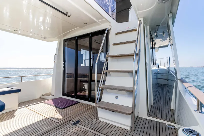 Slide: The Image of Beneteau Swift Trawler 44, 2019, deck view with stairs and sea view. - 24