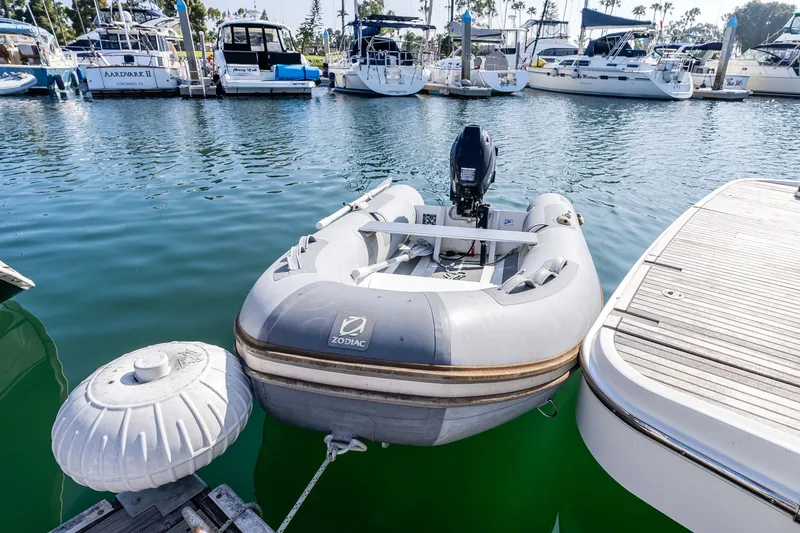 Slide: The Image of Zodiac inflatable boat beside Beneteau Swift Trawler 44 in marina. - 45