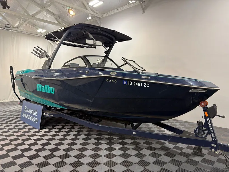 Slide: The Image of 2023 Malibu 26 LSV boat on trailer in showroom. - 2