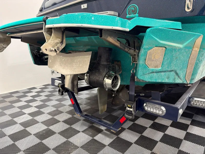 Slide: The Image of Rear view of a 2023 Malibu 26 LSV boat on checkered floor. - 4