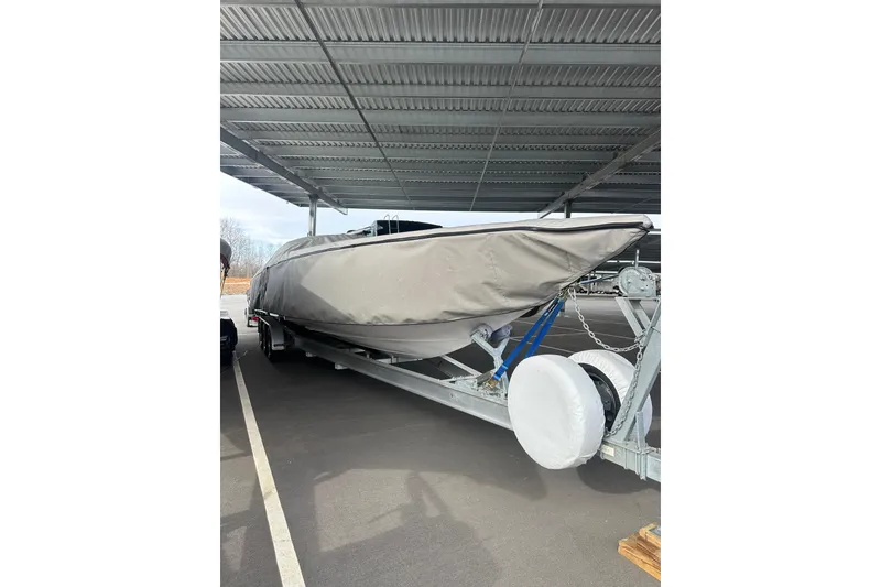 Slide: The Image of 2007 Donzi 35 ZR boat covered and parked on a trailer under a shelter. - 11