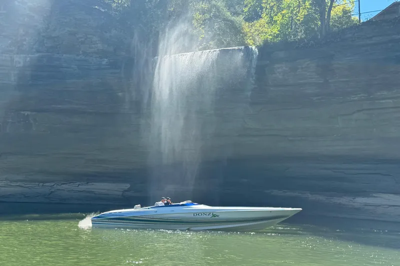 Slide: The Image of 2007 Donzi 35 ZR boat cruising near a scenic waterfall and rocky cliff. - 37