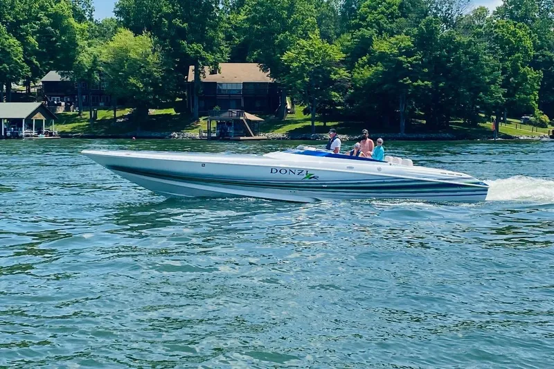 Slide: The Image of 2007 Donzi 35 ZR speedboat cruising on a lake surrounded by trees. - 5