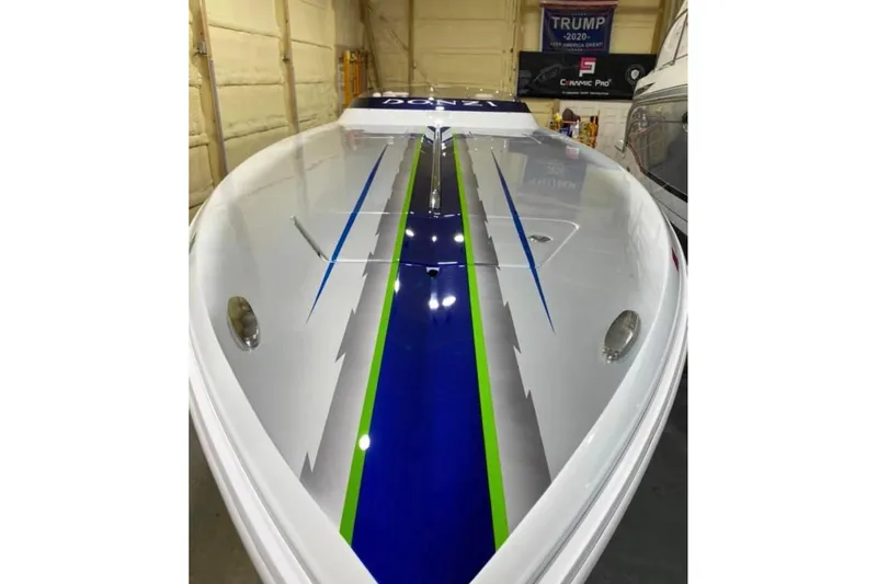 Slide: The Image of 2007 Donzi 35 ZR speedboat with sleek blue and green accents in a garage setting. - 6