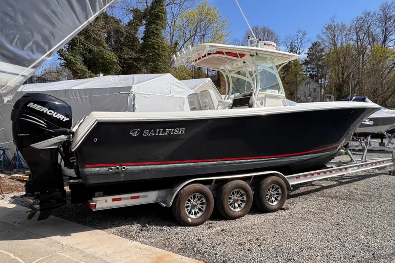 The Image of 2015 Sailfish 320 CC boat on trailer with Mercury engine, parked outdoors. - 0
