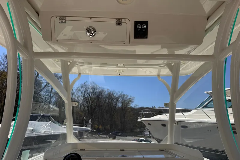 Slide: The Image of Interior view of 2015 Sailfish 320 CC boat with clear sky and docked boats. - 11