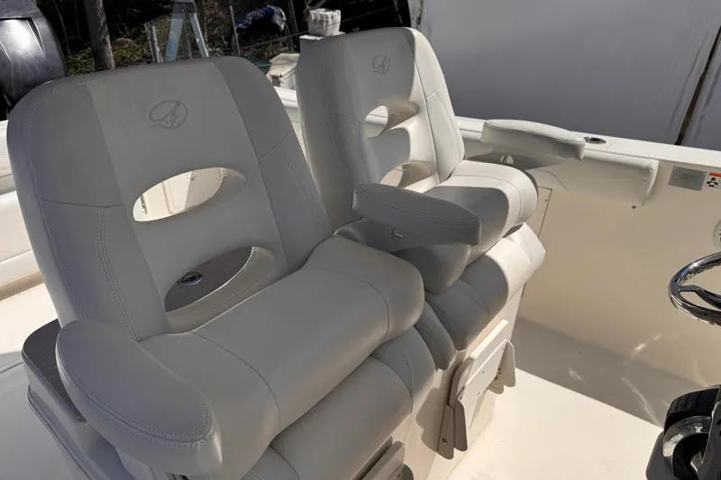 Slide: The Image of Luxury seating on 2015 Sailfish 320 CC boat, featuring plush white captain's chairs. - 12