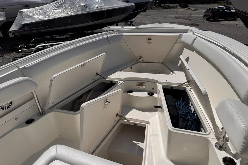 Slide: The Image of 2015 Sailfish 320 CC boat interior with open storage compartments and seating. - 16