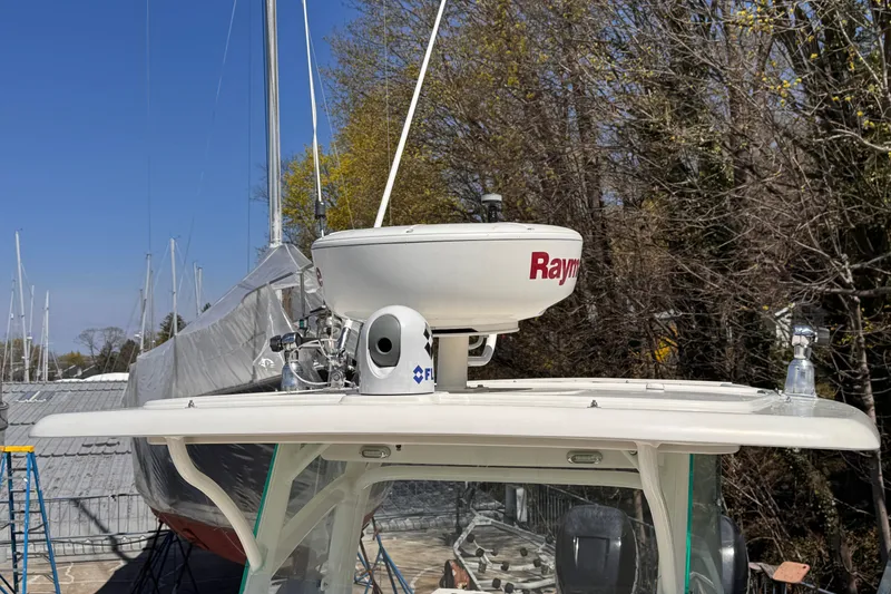Slide: The Image of 2015 Sailfish 320 CC boat with radar equipment on top, surrounded by trees and other boats. - 23
