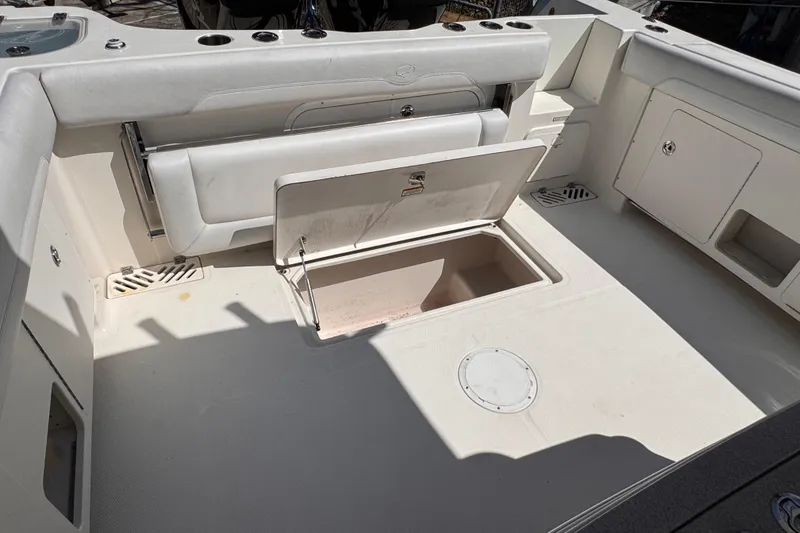 Slide: The Image of 2015 Sailfish 320 CC boat interior with open storage compartment and seating. - 9