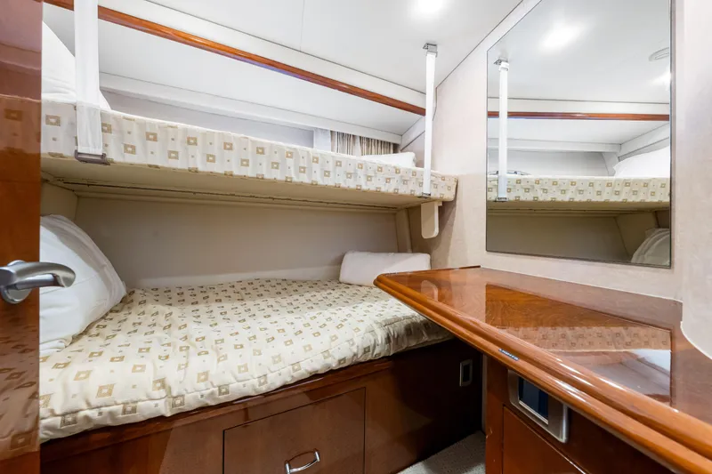 Slide: The Image of Luxurious 2007 Marquis 59 Markham Edition yacht cabin with bunk beds and wooden accents. - 195