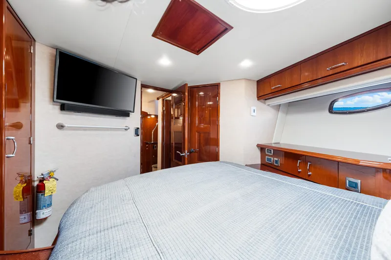 Slide: The Image of Luxurious 2007 Marquis 59 Markham Edition yacht bedroom with TV, wood cabinetry, and ocean view window. - 97