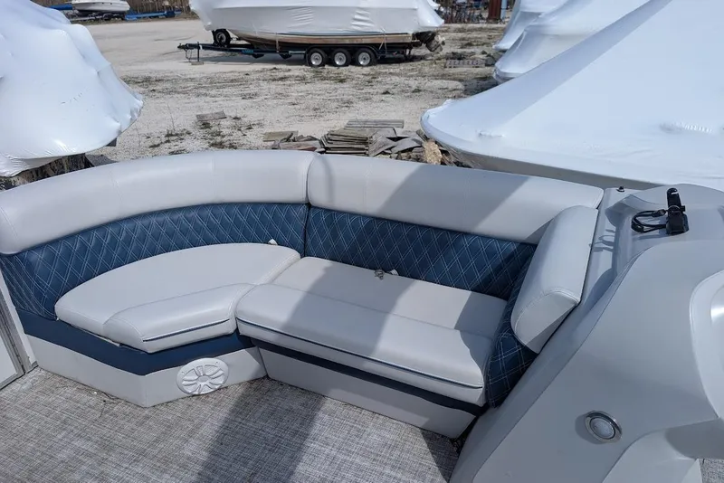 Slide: The Image of 2022 Nepallo 22QL boat interior with blue and white seating, parked outdoors. - 7