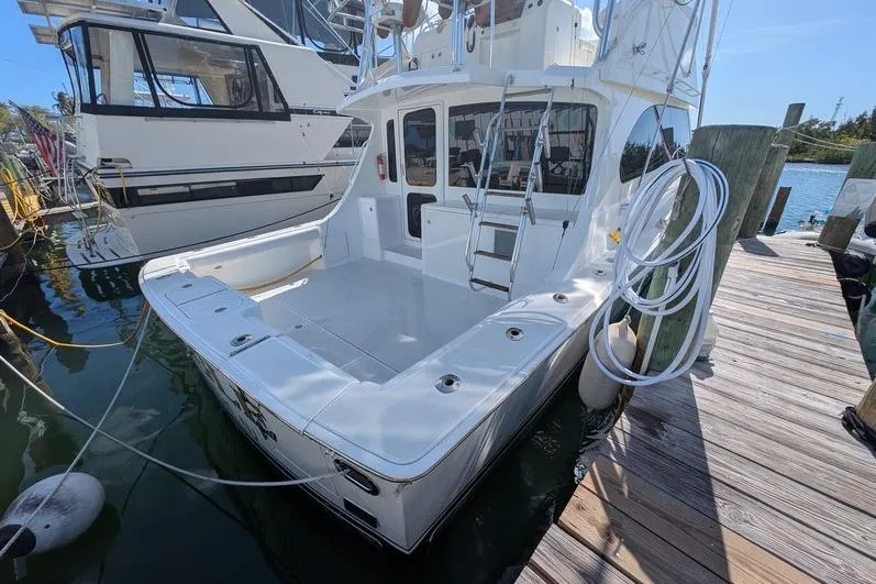 Slide: The Image of 2005 Egg Harbor 43 SportYacht docked, showcasing spacious deck and sleek design. - 103