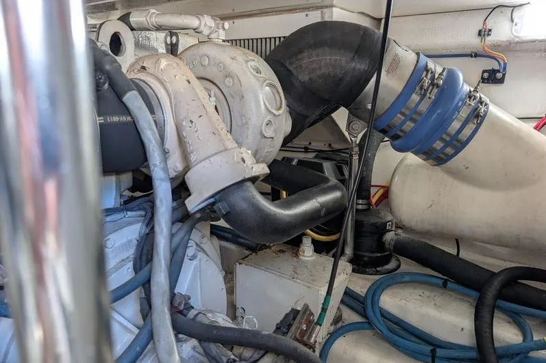 Slide: The Image of Engine room of a 2005 Egg Harbor 43 SportYacht, showcasing mechanical components and hoses. - 115
