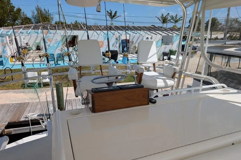 Slide: The Image of 2005 Egg Harbor 43 SportYacht helm with seating, docked near colorful buildings. - 18