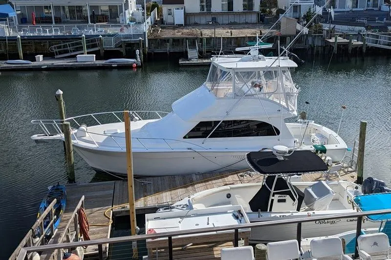 Slide: The Image of 2005 Egg Harbor 43 SportYacht docked in a marina, surrounded by smaller boats. - 3
