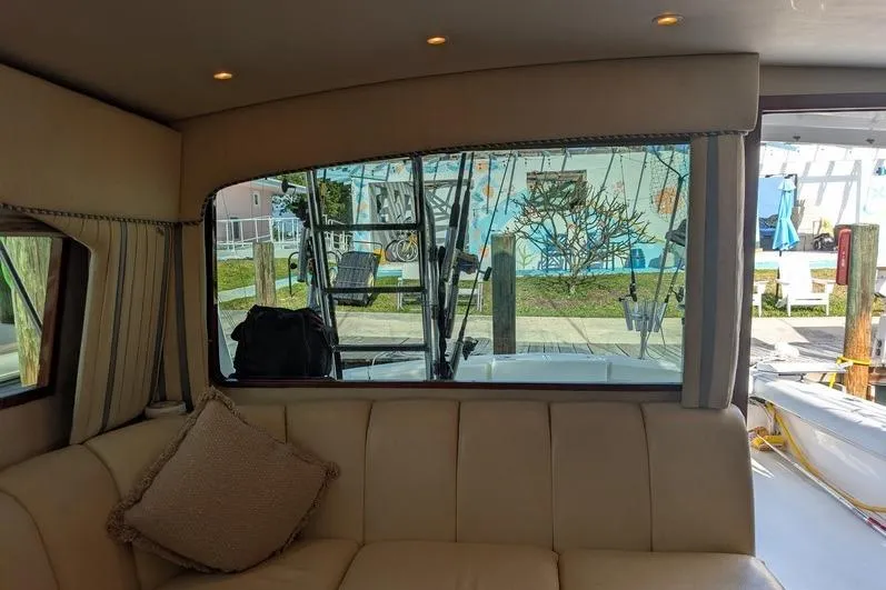 Slide: The Image of Interior view of 2005 Egg Harbor 43 SportYacht with beige seating and marina backdrop. - 34