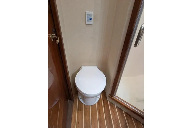 Slide: The Image of Toilet in 2005 Egg Harbor 43 SportYacht bathroom with wooden flooring and shower. - 44
