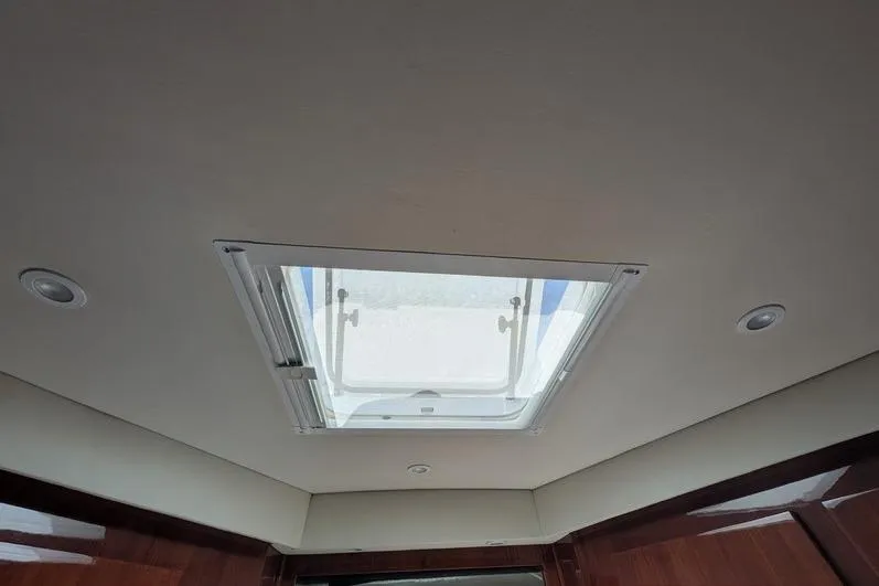 Slide: The Image of Ceiling hatch inside 2005 Egg Harbor 43 SportYacht, featuring recessed lighting and wooden trim. - 54