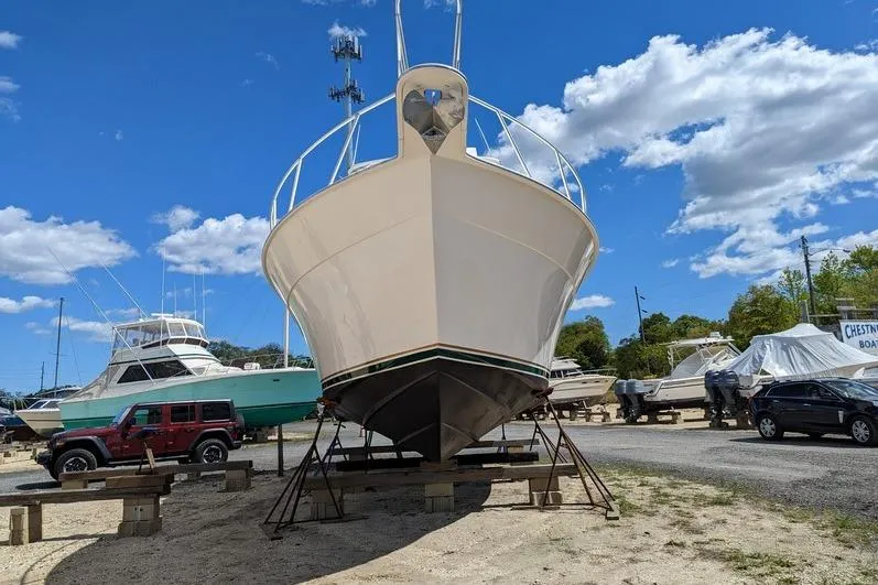 Slide: The Image of 2005 Egg Harbor 43 SportYacht on stands in a boatyard under a clear blue sky. - 6