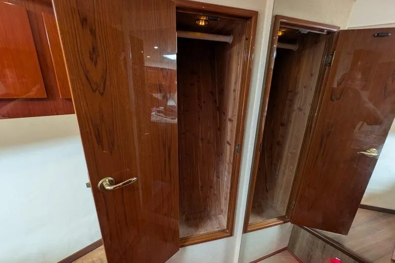 Slide: The Image of Wooden closet interior on a 2005 Egg Harbor 43 SportYacht, showcasing polished doors and ample storage. - 62