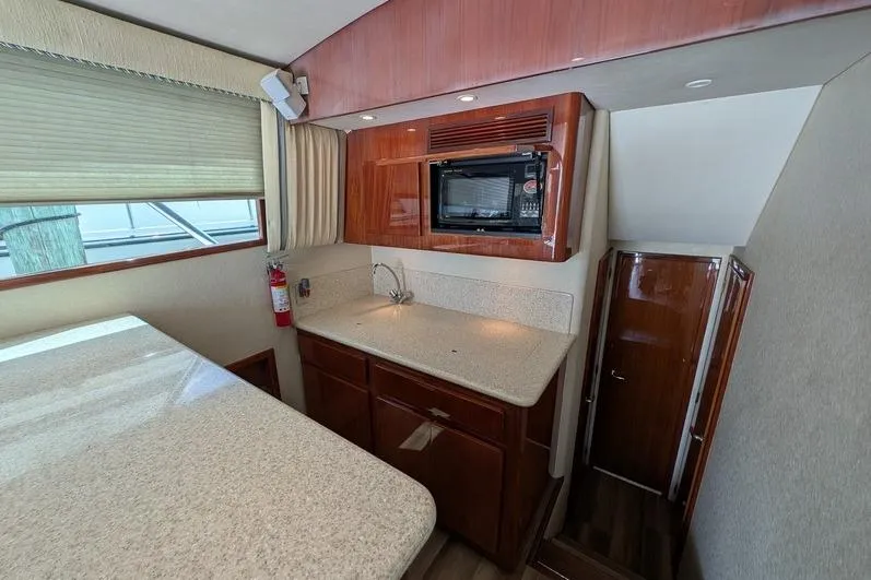 Slide: The Image of 2005 Egg Harbor 43 SportYacht interior kitchen with wood cabinetry and countertop. - 66