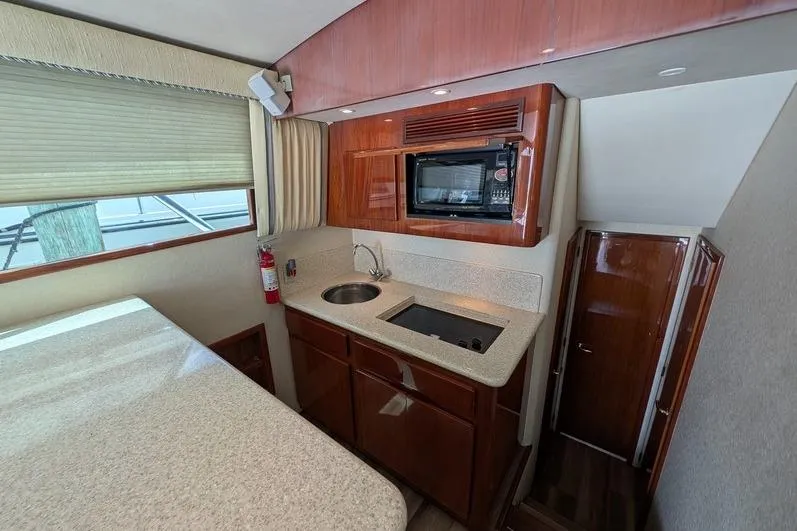 Slide: The Image of Interior of 2005 Egg Harbor 43 SportYacht featuring a compact kitchen with microwave and sink. - 67