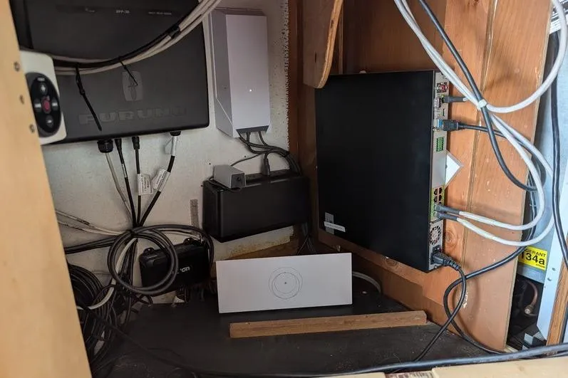 Slide: The Image of Electrical setup inside a 2005 Egg Harbor 43 SportYacht, featuring various cables and devices. - 81