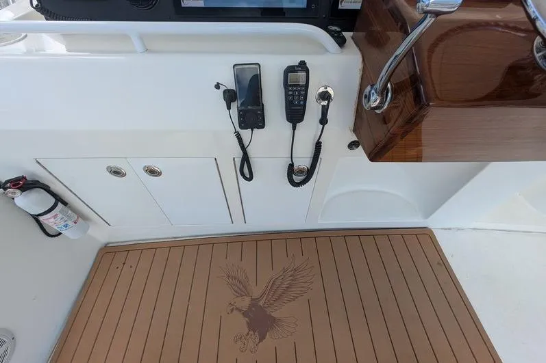 Slide: The Image of Control panel of a 2005 Egg Harbor 43 SportYacht with communication devices and eagle emblem mat. - 88