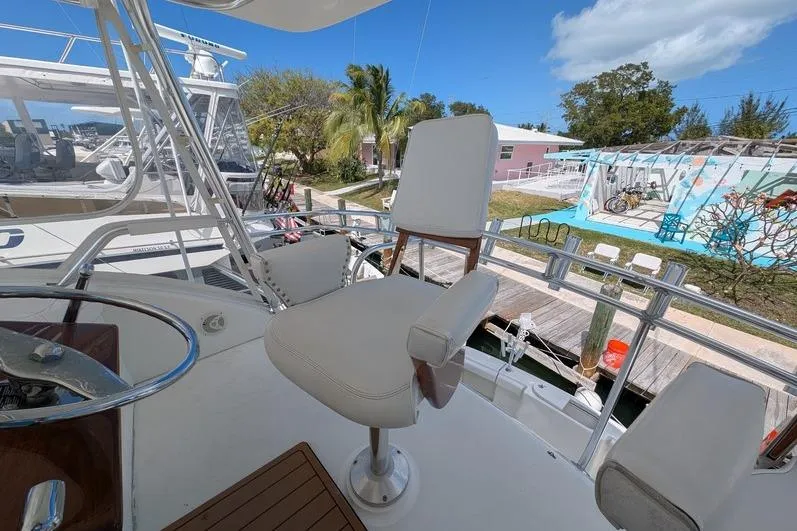 Slide: The Image of Captain's chair on 2005 Egg Harbor 43 SportYacht, docked with clear skies and palm trees. - 95