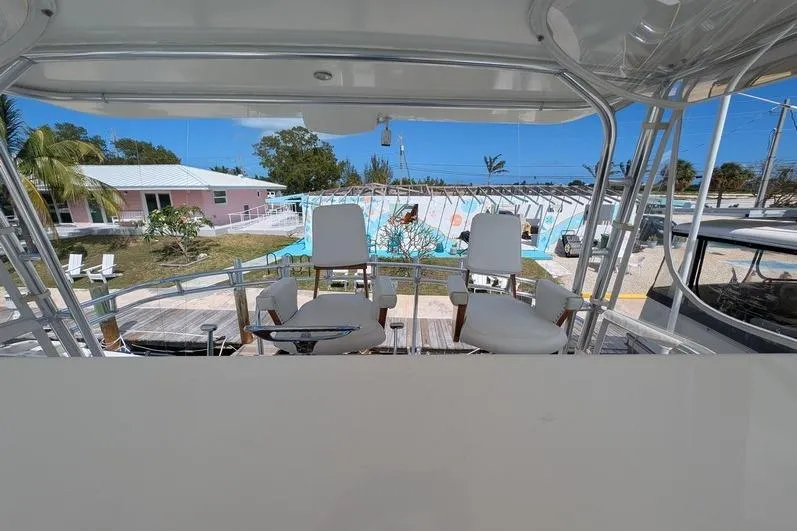 Slide: The Image of 2005 Egg Harbor 43 SportYacht helm with two white captain chairs, overlooking marina. - 97