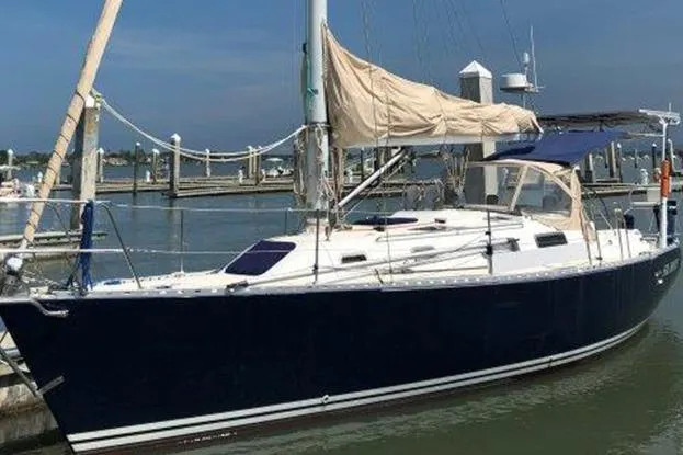 The Image of Sailboat docked at marina, Freedom 35 model, 1995, with blue hull and beige canvas - 0