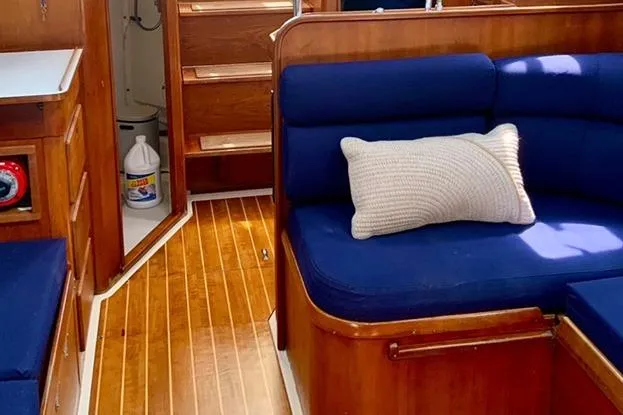 Slide: The Image of Cozy interior of 1995 Freedom 35 sailboat with blue seating and wooden flooring. - 12